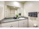This is a bathroom with granite countertops, a sink, a toilet, a large mirror, and a shower behind a curtain at 12728 Feathersong St, Henderson, NV 89044
