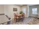 Open concept view of dining area with a wood table, chairs, and a modern light fixture at 12728 Feathersong St, Henderson, NV 89044