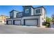 View of new construction townhomes showcasing private garages and modern landscaping at 12728 Feathersong St, Henderson, NV 89044