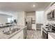 Open-concept kitchen showcasing white cabinets, stainless steel appliances, and views into the living room at 12728 Feathersong St, Henderson, NV 89044