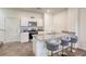 Kitchen features modern island seating with white cabinets and sleek appliances at 12728 Feathersong St, Henderson, NV 89044
