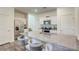 Bright kitchen features white cabinets, stainless steel appliances, and a large granite island with seating at 12728 Feathersong St, Henderson, NV 89044