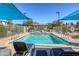 Community pool with lounge chairs, shade canopies, and play area at 12728 Feathersong St, Henderson, NV 89044