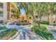 Inviting entrance to the building with lush landscaping and manicured walkways at 220 Flamingo Rd # 210, Las Vegas, NV 89169