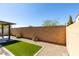 Spacious backyard with a brick wall, desert landscaping, and an artificial turf area at 221 Mountain Cedar Ct, North Las Vegas, NV 89031