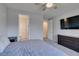 Well-lit bedroom with carpet, ceiling fan, furniture, a television, and en-suite bathroom at 221 Mountain Cedar Ct, North Las Vegas, NV 89031