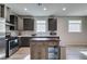 Well-lit kitchen with stainless steel appliances, dark wood cabinets, kitchen island, and stylish backsplash at 221 Mountain Cedar Ct, North Las Vegas, NV 89031