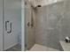 Luxurious walk-in shower featuring gray tiling, glass door, and a built-in bench at 221 Mountain Cedar Ct, North Las Vegas, NV 89031