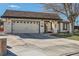 Front exterior view showcasing the driveway, two-car garage, neutral stucco, and well-maintained lawn at 2412 El Cid Ct, Henderson, NV 89014