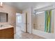 Bright bathroom featuring tiled floors, single vanity, and shower-tub combo with decorative curtain at 2431 Lilac Cove St, Las Vegas, NV 89135