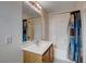 Bathroom with a single sink vanity, large mirror, and shower-tub combo with vibrant curtain at 2431 Lilac Cove St, Las Vegas, NV 89135