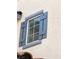 Close up of blue decorative shutters on a stucco exterior wall at 2431 Lilac Cove St, Las Vegas, NV 89135