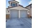 Attached two-car garage with gray doors and concrete driveway on a stucco two-story home at 2431 Lilac Cove St, Las Vegas, NV 89135
