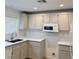 Bright kitchen featuring white cabinets, sleek countertops, and modern appliances at 2431 Lilac Cove St, Las Vegas, NV 89135