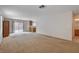 Open-concept living room with sliding glass doors, neutral paint, and carpet flooring at 2431 Lilac Cove St, Las Vegas, NV 89135
