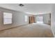 Open-concept living room with sliding glass doors, neutral paint, carpet flooring, and a chandelier at 2431 Lilac Cove St, Las Vegas, NV 89135