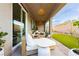 Covered patio with a seating area overlooking the landscaped backyard at 2450 Amatrice St, Henderson, NV 89044