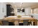 Open-concept dining area with wooden table and chairs, flowing into a modern kitchen with dark cabinetry and white island at 2450 Amatrice St, Henderson, NV 89044