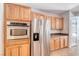 Close up view of stainless fridge, built-in oven, and wooden cabinetry at 2528 Flodden St, Henderson, NV 89044