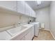 Convenient laundry room with sink, storage cabinets and tile floor at 2528 Flodden St, Henderson, NV 89044