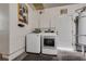 A well-lit laundry room featuring a washer, dryer and exterior access door at 2532 Whippoorwill Ln, Las Vegas, NV 89121
