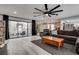 Bright living room featuring a large fan, grey flooring, and direct access to an outdoor seating area through sliding glass doors at 2532 Whippoorwill Ln, Las Vegas, NV 89121