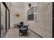 Cozy outdoor patio featuring brick flooring, seating, and a decorative sun ornament on a stucco wall at 2532 Whippoorwill Ln, Las Vegas, NV 89121