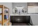 Modern bathroom with dual sinks, dark cabinetry, round mirrors, and a wooden shelf at 257 Pinnacle Ct, Mesquite, NV 89027