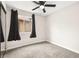 A cozy bedroom with a ceiling fan, carpet, and large windows with black curtains at 2793 Sandyfalls Way, Las Vegas, NV 89142