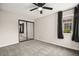 A spacious bedroom with a ceiling fan, carpet, closet and window with black curtains at 2793 Sandyfalls Way, Las Vegas, NV 89142