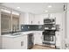 Modern kitchen with stainless steel appliances, white cabinets, and blue backsplash at 2793 Sandyfalls Way, Las Vegas, NV 89142