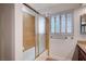Bathroom featuring a shower over tub with sliding doors and shuttered windows at 2916 W Oakey Blvd, Las Vegas, NV 89102