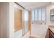 Bathroom featuring a tub with sliding glass doors and a window with wooden shutters at 2916 W Oakey Blvd, Las Vegas, NV 89102