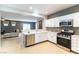 Bright kitchen with stainless steel appliances and white cabinetry adjacent to open-concept living area at 2970 Strathspey Ct, Henderson, NV 89044