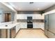 Well-lit kitchen featuring stainless steel appliances, white cabinets, and tiled backsplash and flooring at 2970 Strathspey Ct, Henderson, NV 89044