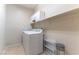 Functional laundry room with modern washer, dryer, storage, and shelving at 2970 Strathspey Ct, Henderson, NV 89044