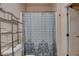 Bathroom showcases a patterned shower curtain, toilet, and metal shelving unit at 3140 Unicorn Ave, Pahrump, NV 89048