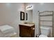 Bathroom features a dark wood vanity with granite top, toilet, and chrome shelving unit at 3140 Unicorn Ave, Pahrump, NV 89048