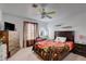 Cozy bedroom with a dark wood bed frame, colorful ceiling fan, and carpeted floors at 3140 Unicorn Ave, Pahrump, NV 89048