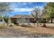 Charming brick home with desert landscaping and mature trees on a sunny day at 3140 Unicorn Ave, Pahrump, NV 89048