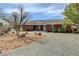 Brick ranch-style home with desert landscaping, comfortable seating and gravel driveway at 3140 Unicorn Ave, Pahrump, NV 89048