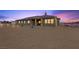 Inviting home exterior features lighted windows, stucco siding, covered patio, and desert landscaping at 3600 E Bridger St, Pahrump, NV 89061