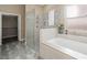 Bright bathroom with a soaking tub, glass-enclosed shower, and a walk-in closet for ample storage at 3600 E Bridger St, Pahrump, NV 89061