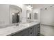Bathroom featuring dual vanities with marble countertops and tiled shower at 3600 E Bridger St, Pahrump, NV 89061