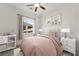 Bedroom features a ceiling fan, large window, and neutral colors at 3600 E Bridger St, Pahrump, NV 89061