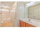 Clean bathroom featuring a shower-tub combo, and wood-stained vanity with sink and mirror at 3958 Blushing Hearts Rd, Las Vegas, NV 89115