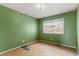 Bedroom featuring green walls, a window, and tile-pattern flooring at 4155 Comb Cir, Las Vegas, NV 89104