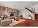 Staged living room showcases a brick fireplace, staircase, sofa, and decorations at 4155 Comb Cir, Las Vegas, NV 89104