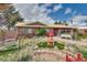 A charming front yard featuring a swing, garden decorations, and mature landscaping at 4300 Thom Blvd, Las Vegas, NV 89130