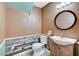 Charming half bath with rustic wood accent wall, round mirror, and pedestal sink at 4431 Palm Mesa Dr, Las Vegas, NV 89120
